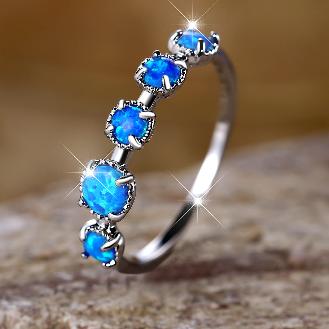 Anillo de diseño sencillo con cinco ópalos blancos y azules de Olivenorma