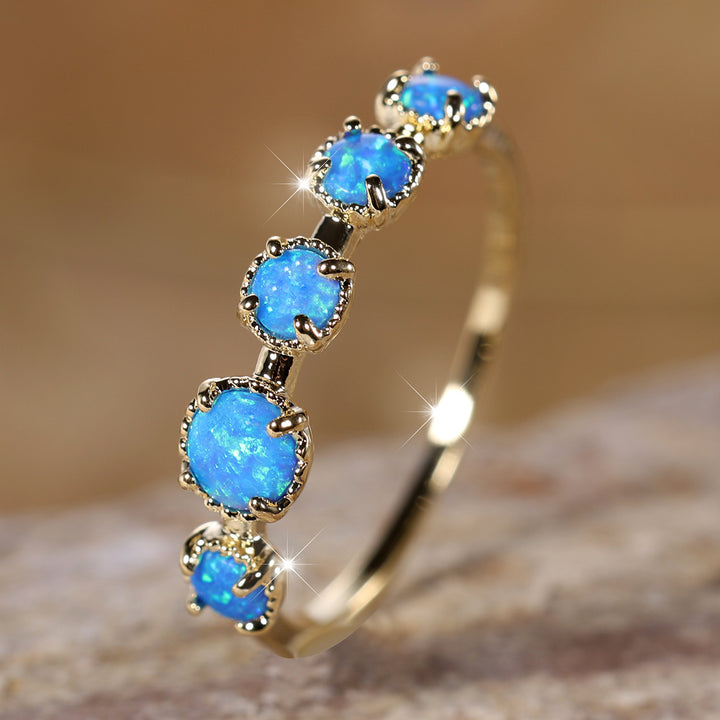 Anillo de diseño sencillo con cinco ópalos blancos y azules de Olivenorma