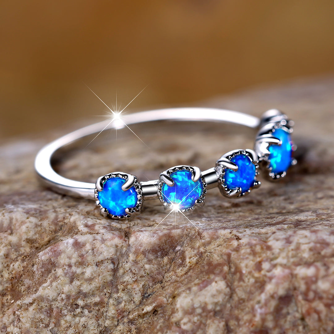 Anillo de diseño sencillo con cinco ópalos blancos y azules de Olivenorma