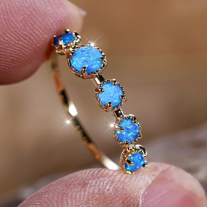 Anillo de diseño sencillo con cinco ópalos blancos y azules de Olivenorma