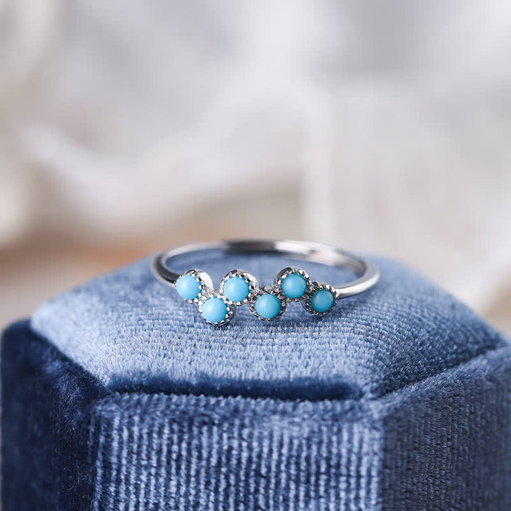 Anillo de pareja creativo de cuatro garras con turquesa redonda de Olivenorma