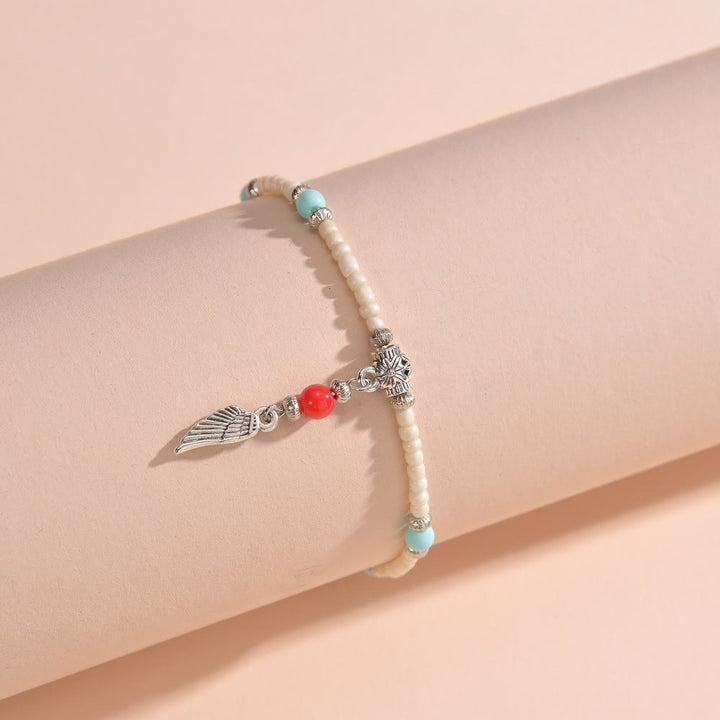 Tobillera con colgante de plumas de metal con cuentas de turquesa blanca de Olivenorma