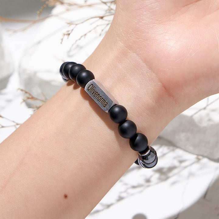 Pulsera con cuentas de hematita y ónix negro grabada de Olivenorma