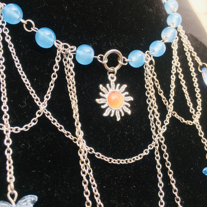 Gargantilla en capas de aguamarina con mariposa y sol de Olivenorma