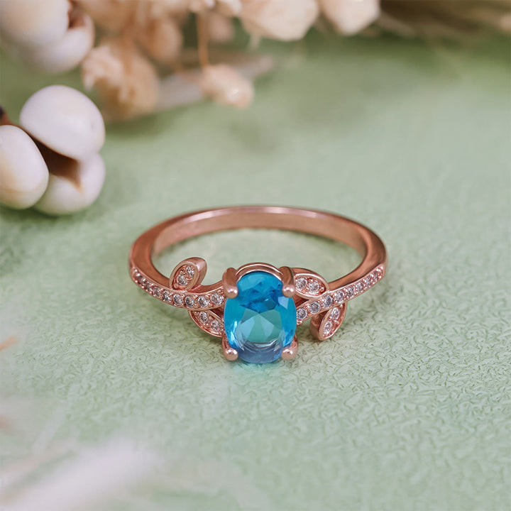Anillo de hojas envueltas con topacio azul de talla ovalada de Olivenorma