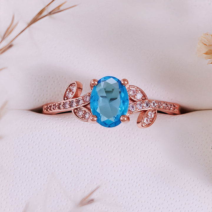 Anillo de hojas envueltas con topacio azul de talla ovalada de Olivenorma