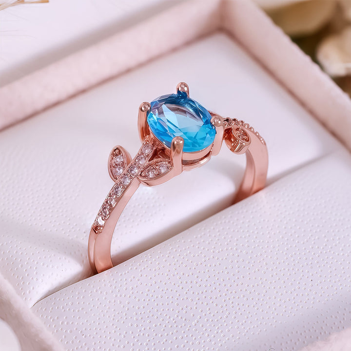 Anillo de hojas envueltas con topacio azul de talla ovalada de Olivenorma