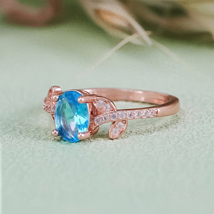 Anillo de hojas envueltas con topacio azul de talla ovalada de Olivenorma