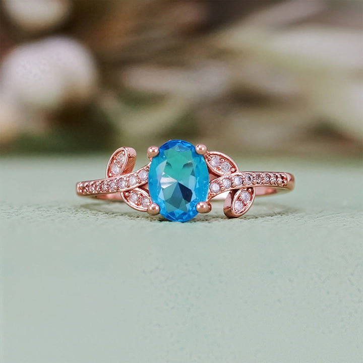 Anillo de hojas envueltas con topacio azul de talla ovalada de Olivenorma