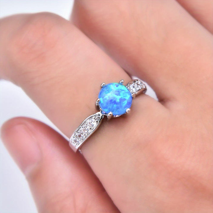 Anillo de banda con borde de ópalo redondo y seis garras de Olivenorma