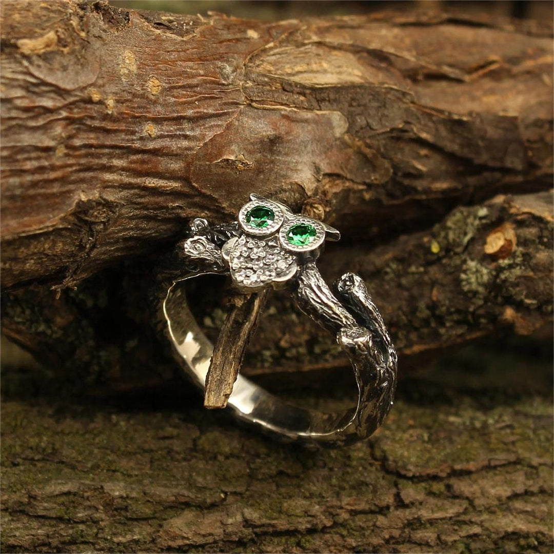 Anillo de compromiso de plata con búho en la rama y esmeralda de Olivenorma 