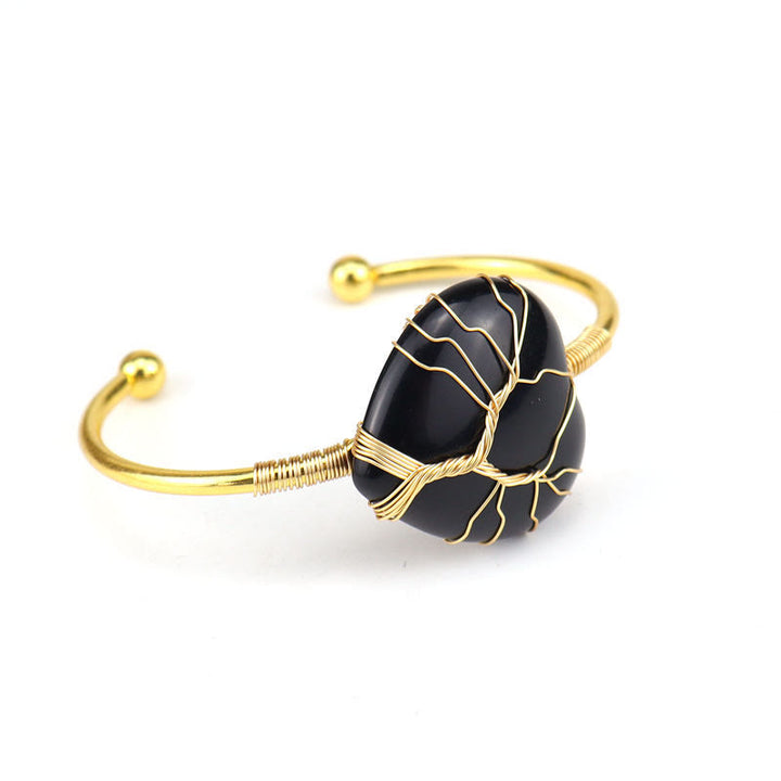 Pulsera de cristal natural en forma de corazón envuelta en alambre de cobre y oro de Olivenorma.