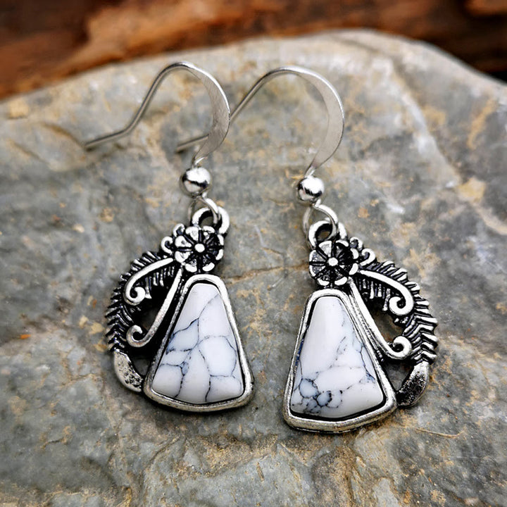 Pendientes de plumas talladas en plata y turquesa blanca de Olivenorma
