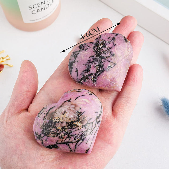 Piedra de juego pulida de rodonita de Olivenorma con forma de corazón de cristal