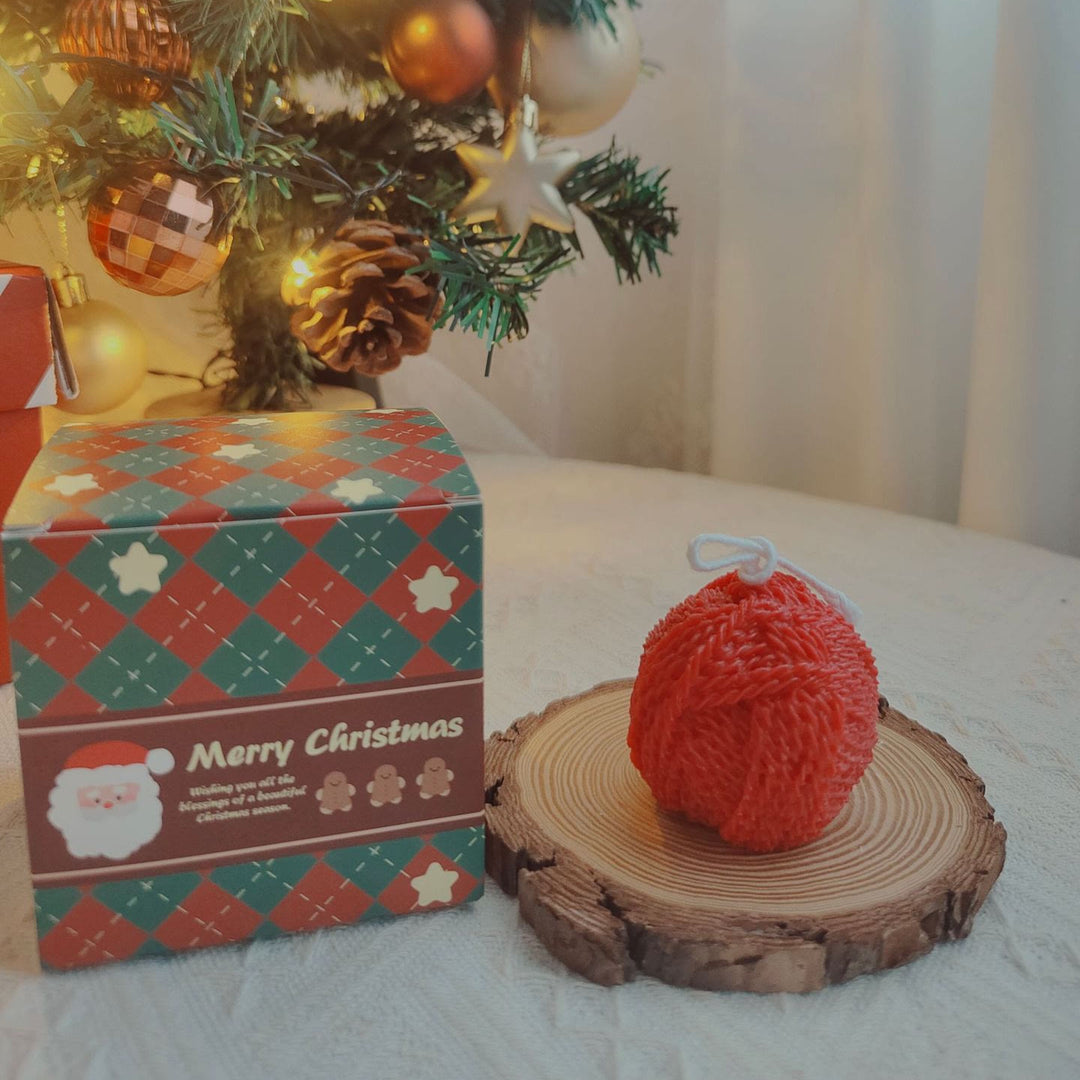 Vela con forma de calcetín navideño hecha con ovillo de lana y guante grabado de Olivenorma 